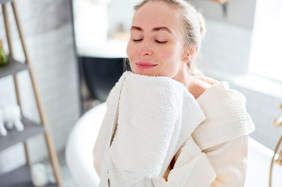 Woman wiping face using a washcloth in bathroom