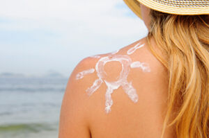 Sun-shaped sunscreen on woman's shoulder