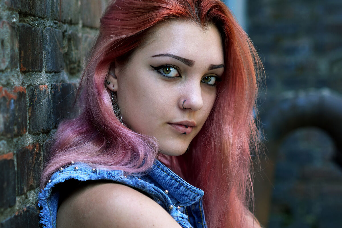 Portrait of street punk or hipster girl with pink dyed hair and lip pierced