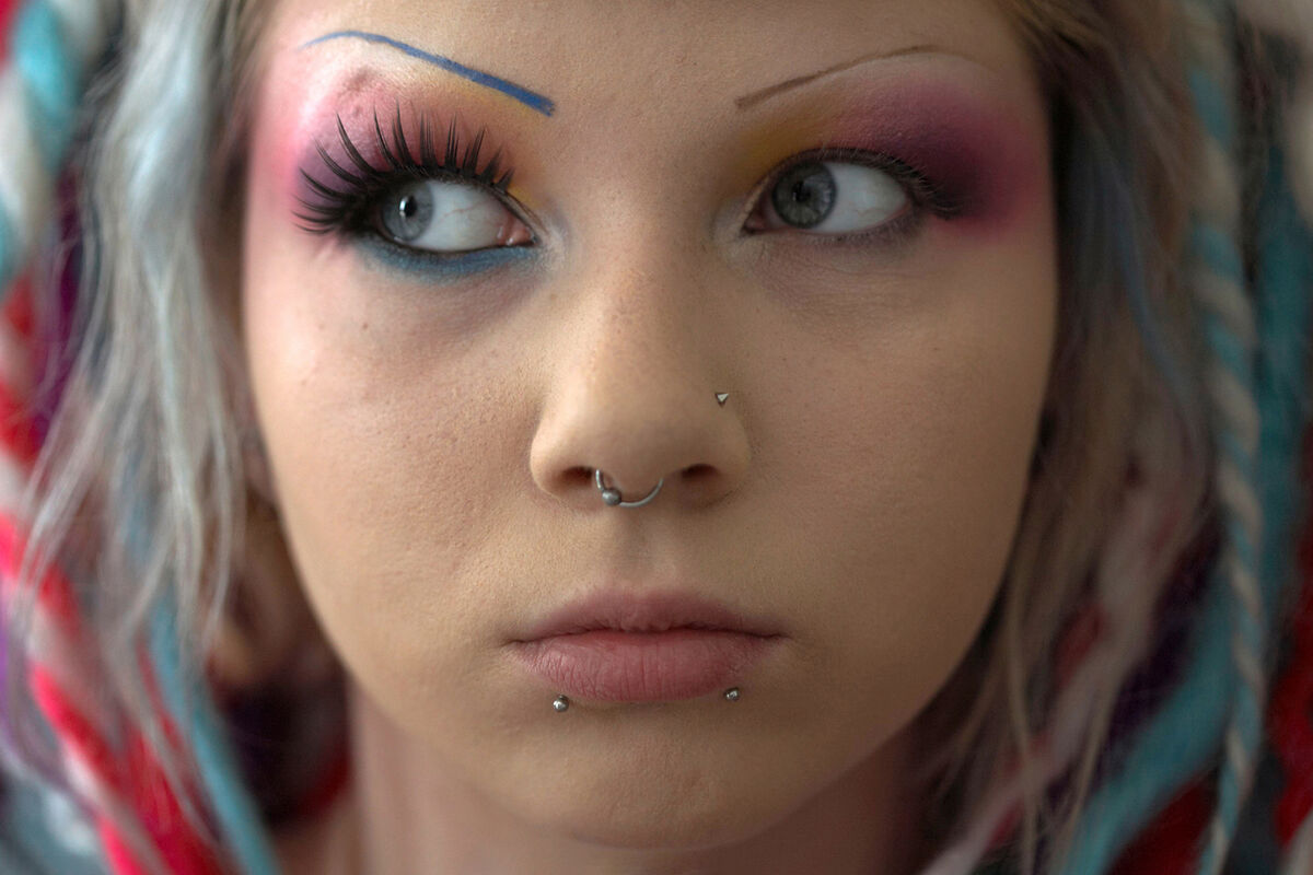 Close-up of a woman's face with make-up and facial piercings
