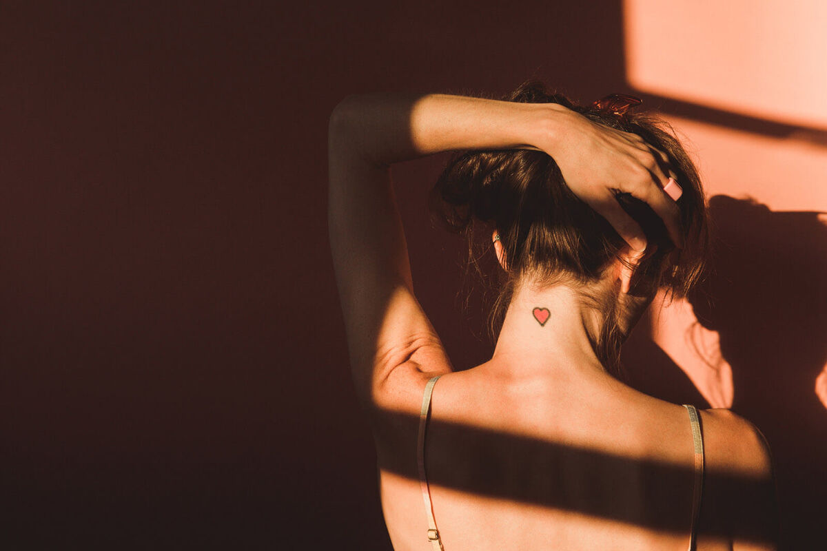 Woman Back View with Heart Tattoo on Neck