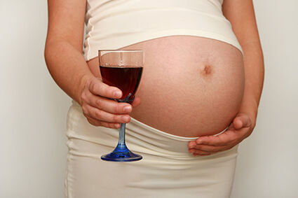 Pregnant woman with glass of wine