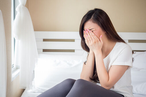 stressed woman sitting on bed