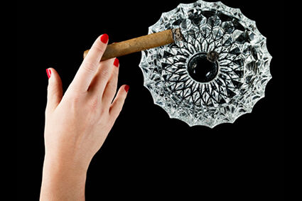 Female hand with cigar and ashtray