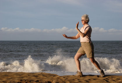 Senior woman practicing tai chi on the beach
