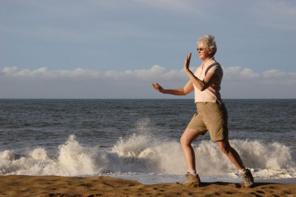 Senior woman practicing tai chi on the beach