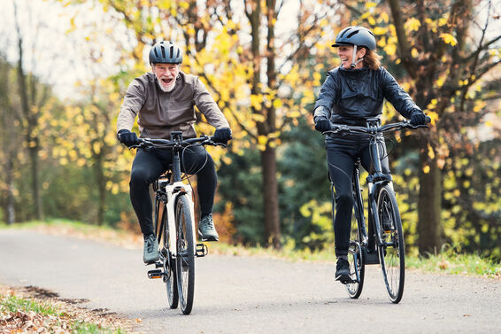 Seniors wearing helmets having fun on bikes
