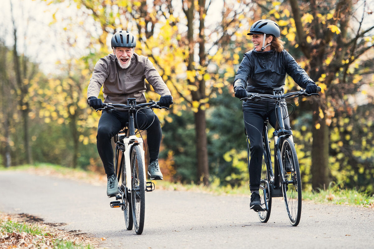 Seniors wearing helmets having fun on bikes