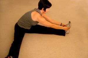 Woman sitting on floor and stretching
