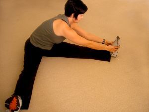 Woman sitting on floor and stretching