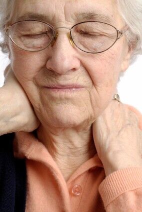Elderly woman rubbing her painful neck