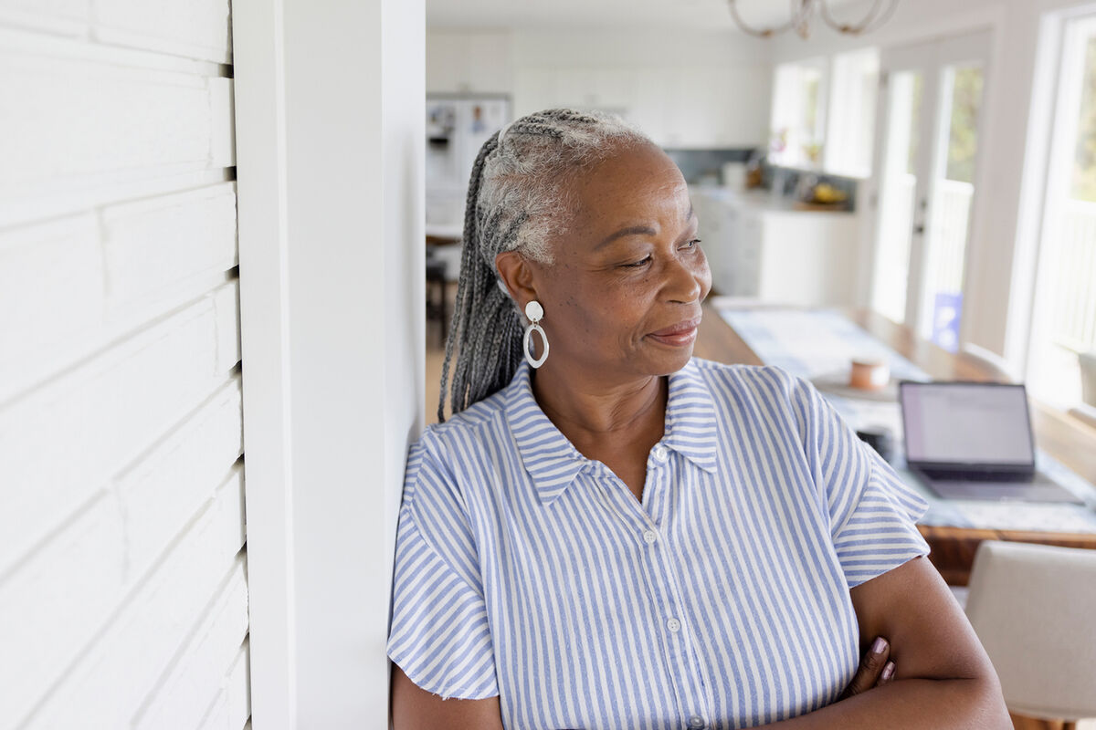 Portrait smiling, thoughtful senior woman in doorway at home