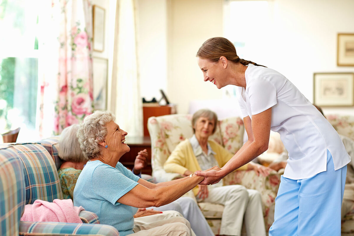 Nurse holding senior woman's hand