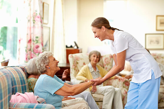 Nurse holding senior woman's hand