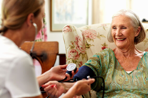 Caretaker measuring pressure largest assisted living companies