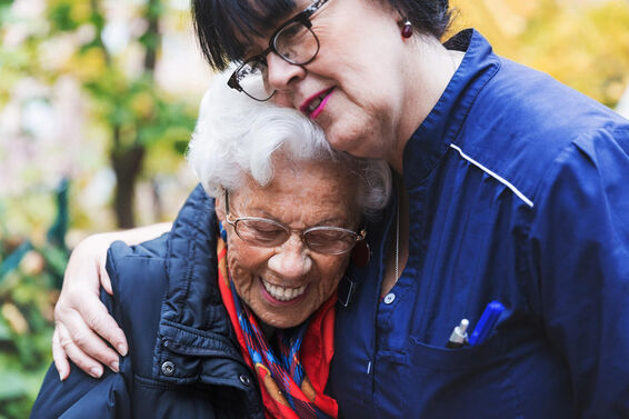 Caretaker embracing senior woman