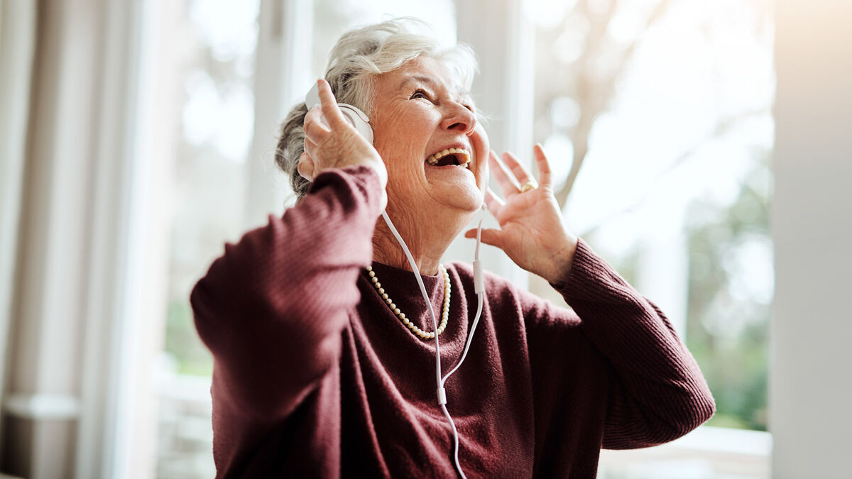 Happy senior woman listening to music with headphones