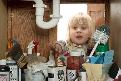 little girl reaching under sink