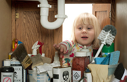little girl reaching under sink