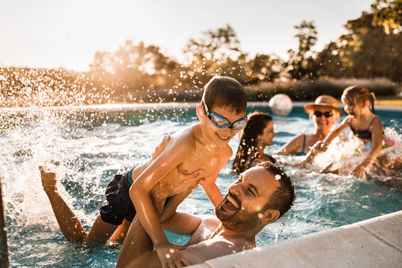 Cheerful father and son having fun in the swimming pool