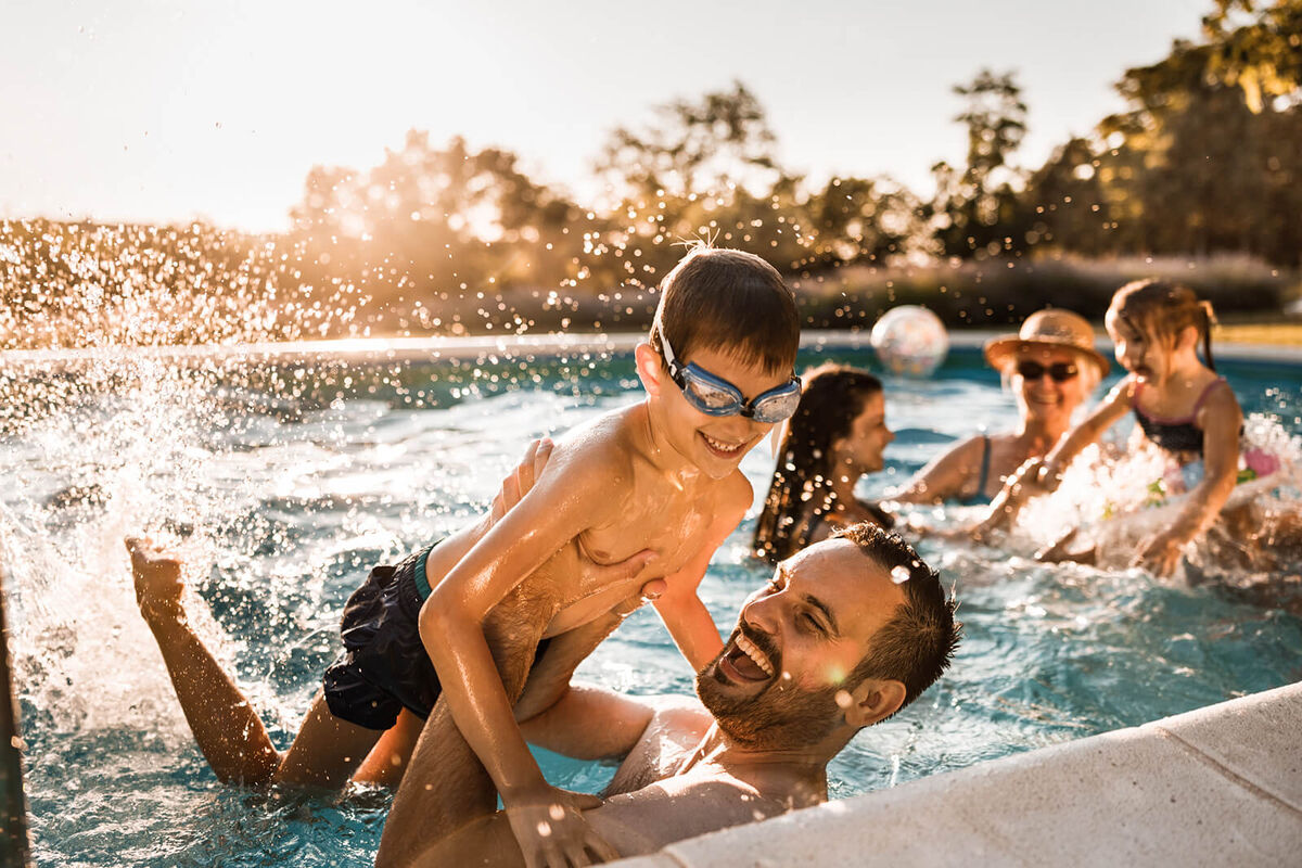 Cheerful father and son having fun in the swimming pool