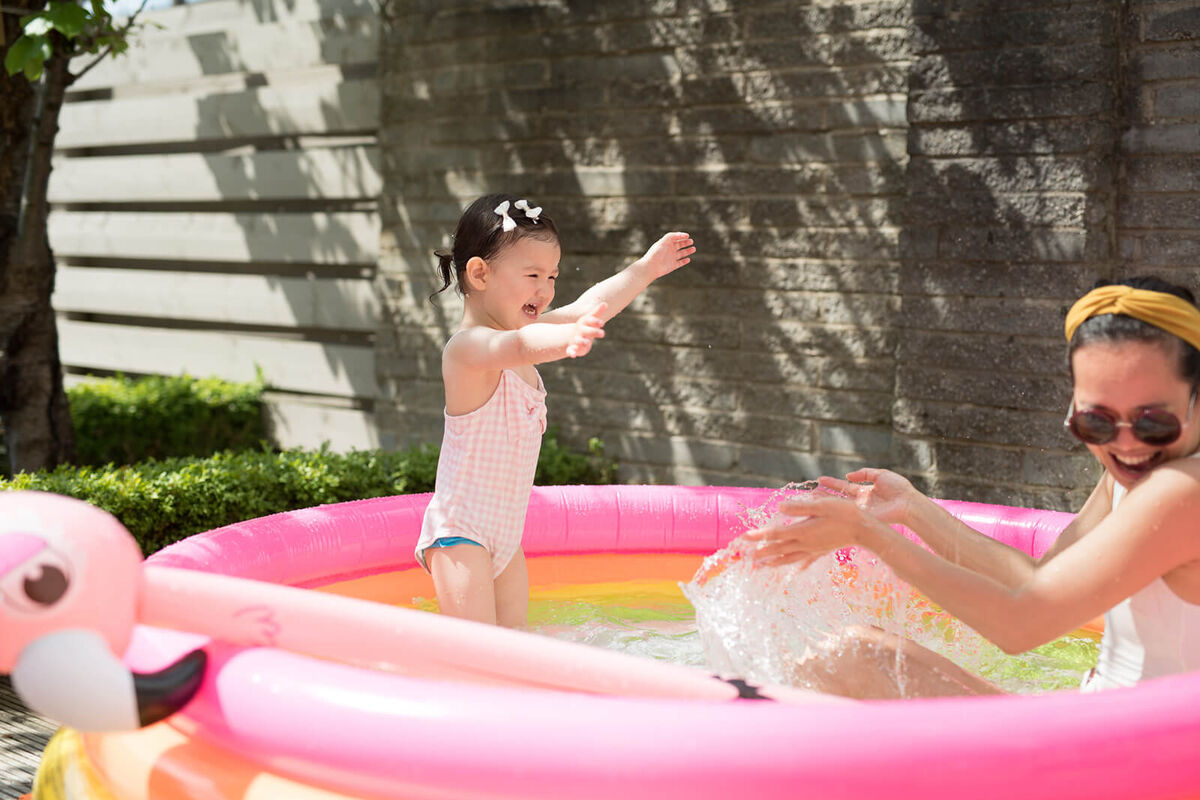 A toddler splashes water on her mother