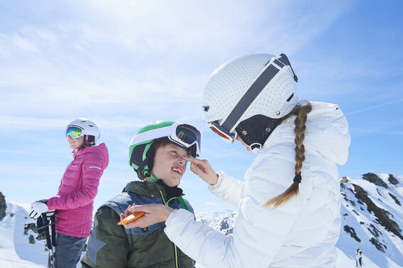 Mother putting sunscreen on son