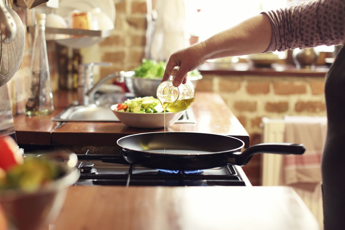 Pouring olive oil on pan