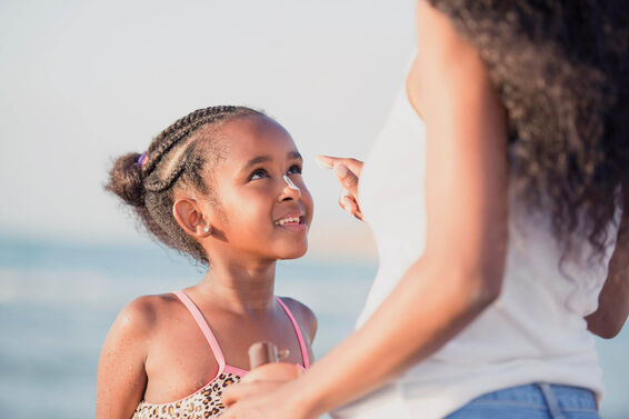 Mother applying sun protection cream to daughter