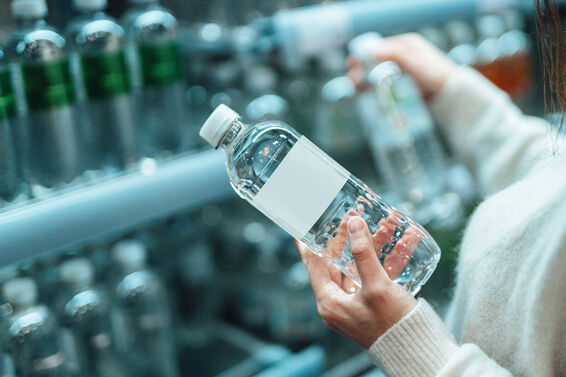 Woman buying bottled water in convenience store