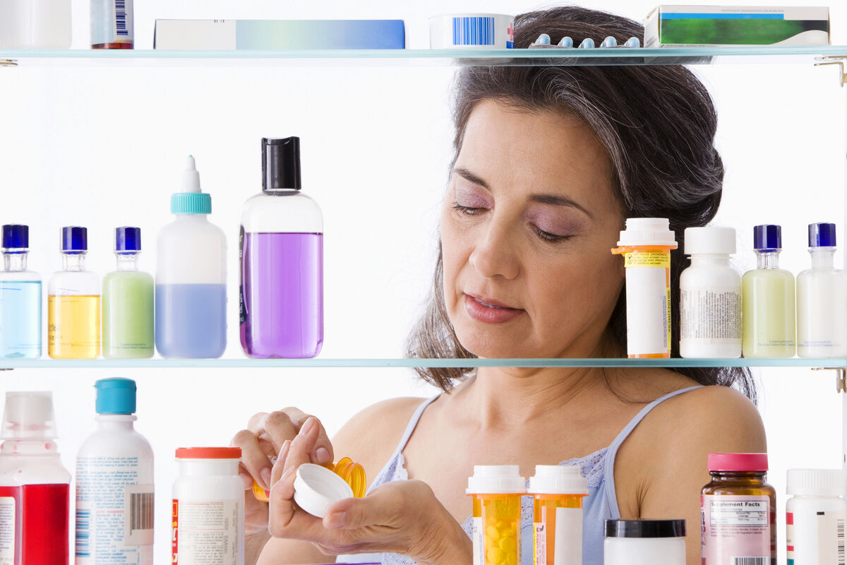 Hispanic woman taking medication in bathroom