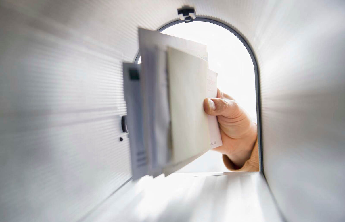 man's hand removing letters from letter box