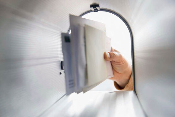 man's hand removing letters from letter box