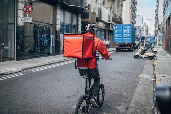 Delivery boy on bicycle in city