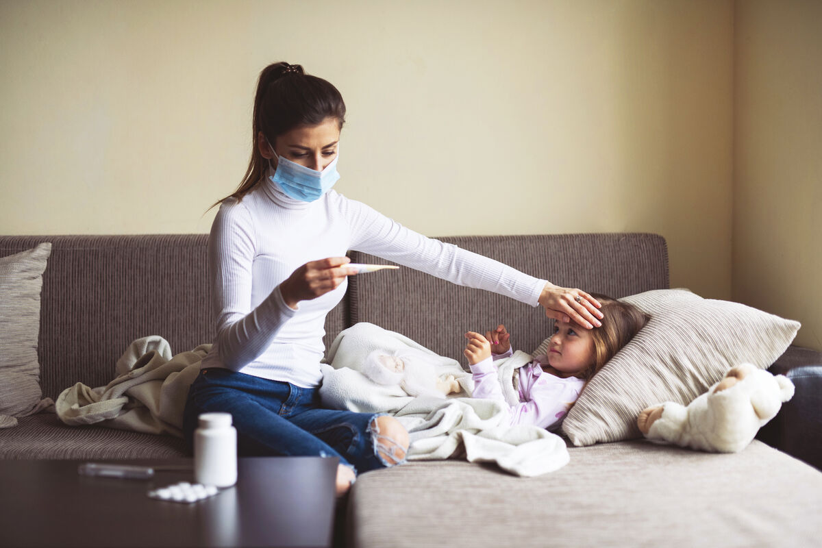 A Mother Measure Temperature On Her Sick Child At Home