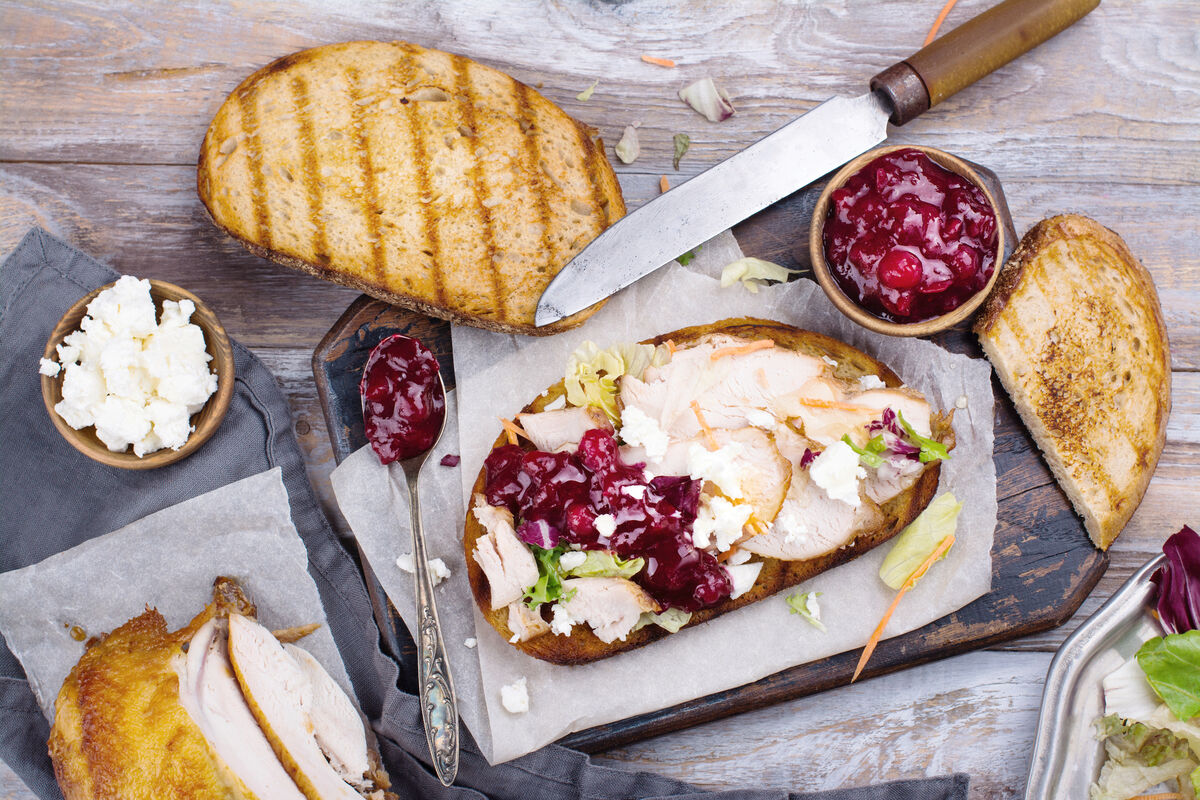 Homemade leftover thanksgiving sandwich with turkey, cranberry sauce, feta cheese and vegetables